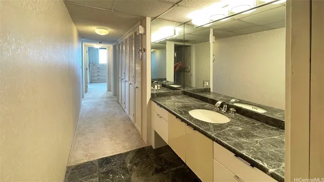 a bathroom with a granite countertop sink and a mirror