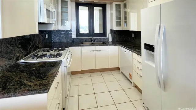 a kitchen with a sink a stove and cabinets