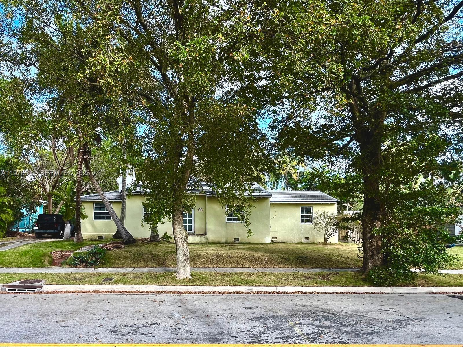 901 Northwest 10th Court Miami, FL 33136 - Photo 5 of 13 a view of a house with a yard and large trees