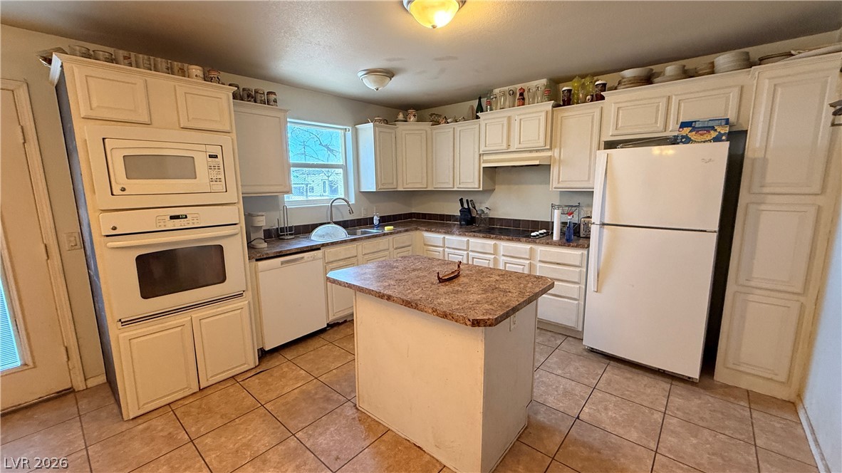 855 Spring Road Indian Springs, NV 89018 - Photo 2 of 13 Functional cabinetry pairs with tile flooring in this classic cooking space.