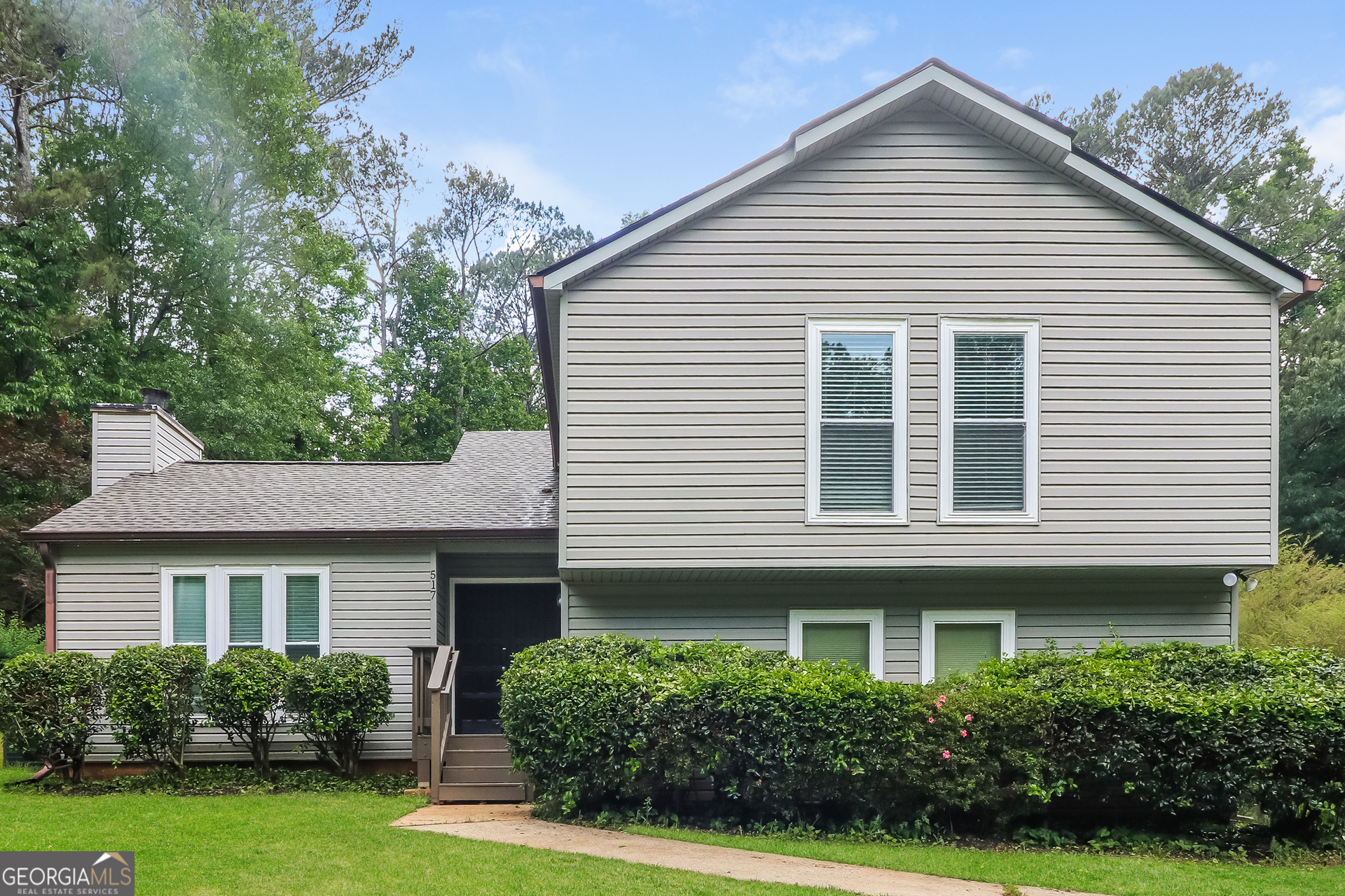 a view of a white house next to a yard