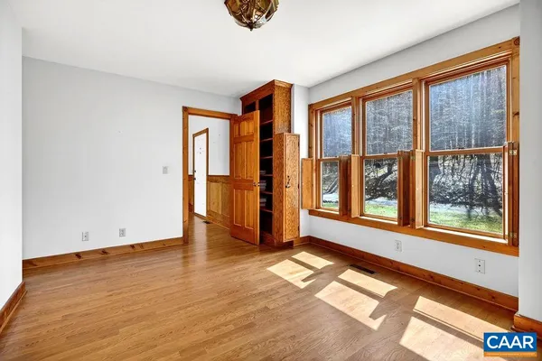 a view of a hallway with wooden floor and stairs