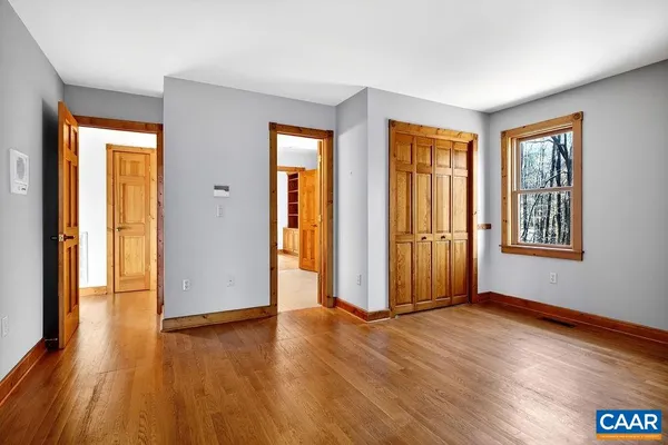 an empty room with wooden floor and windows