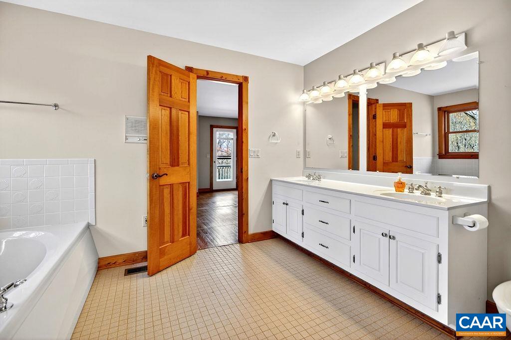 472 Horseshoe Mountain Road Roseland, VA 22967 - Photo 32 of 75 a spacious bathroom with a double vanity sink a mirror and a bathtub