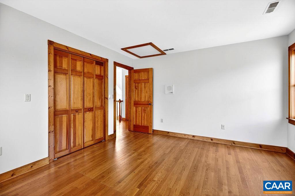 472 Horseshoe Mountain Road Roseland, VA 22967 - Photo 57 of 75 an empty room with wooden floor and a ceiling fan