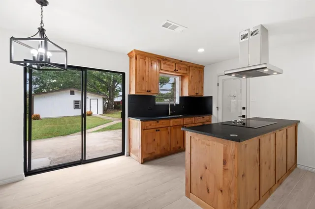 a kitchen with stainless steel appliances granite countertop a stove a sink and a refrigerator