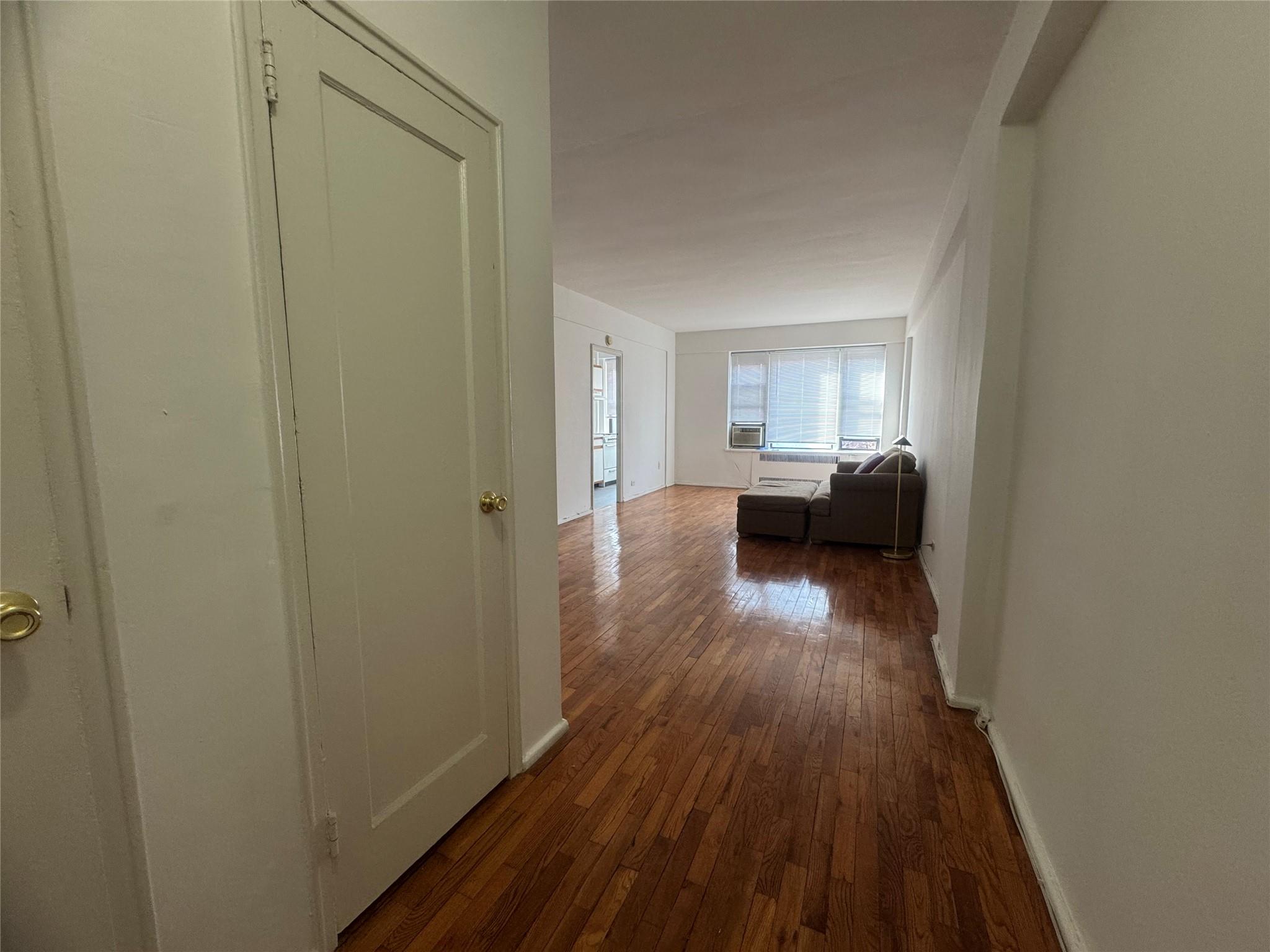 99-21 67th Road, Unit 7K Queens, NY 11375 - Photo 4 of 10 a view of a livingroom with wooden floor and a window