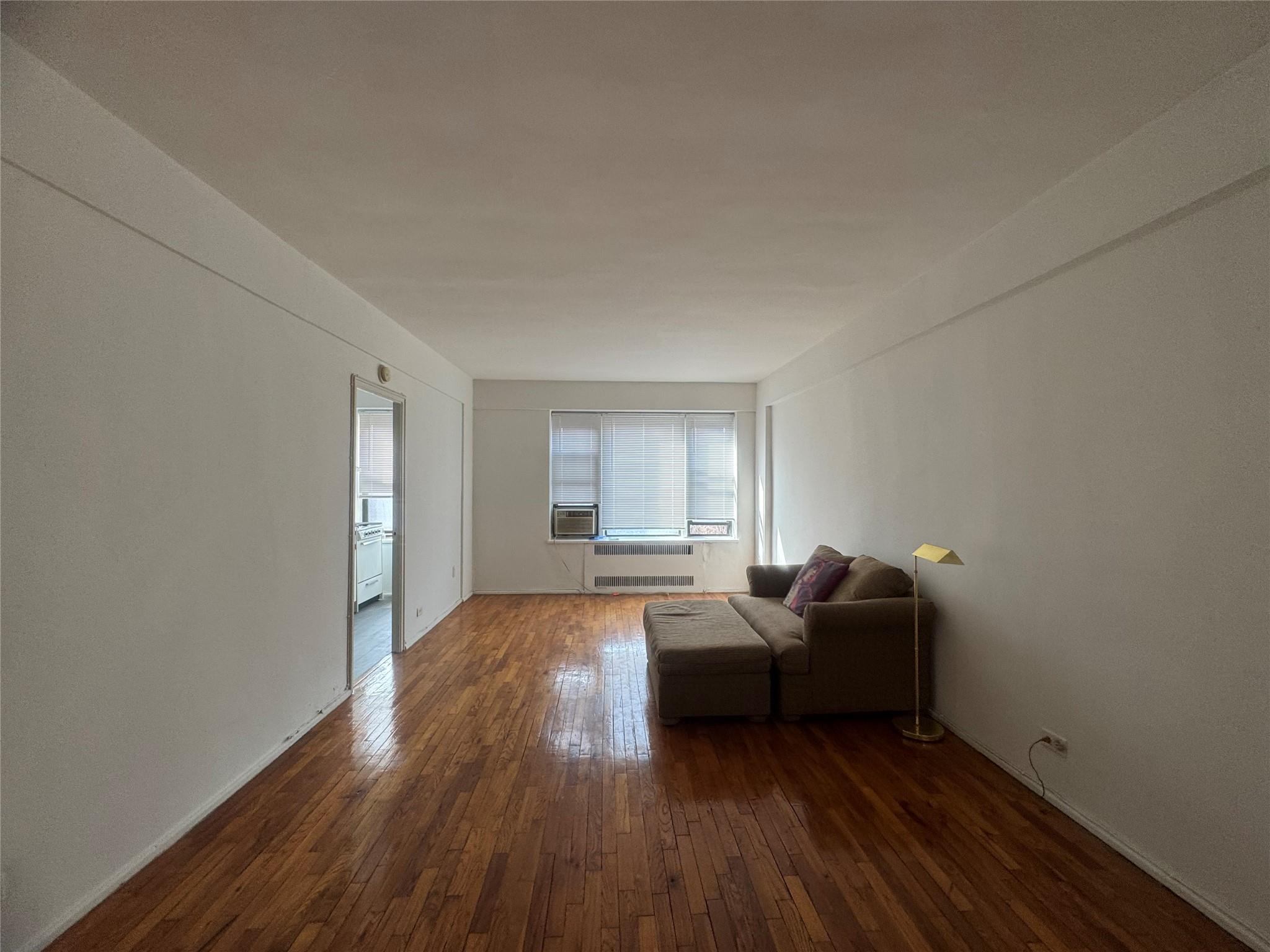 99-21 67th Road, Unit 7K Queens, NY 11375 - Photo 5 of 10 a living room with furniture and a wooden floor