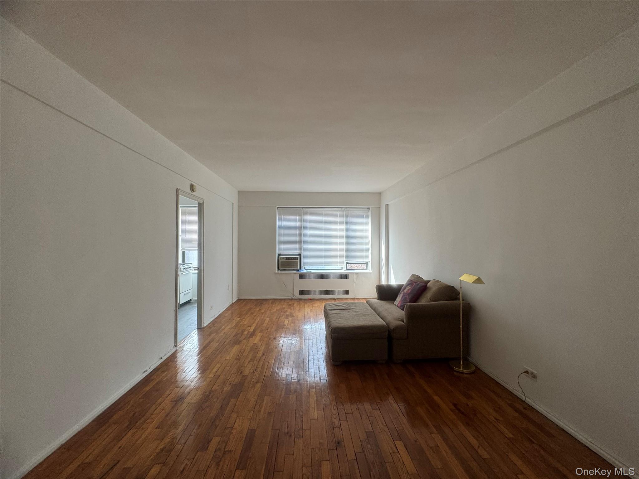 99-21 67th Road, Unit 7K Queens, NY 11375 - Photo 5 of 10 a living room with furniture and a wooden floor