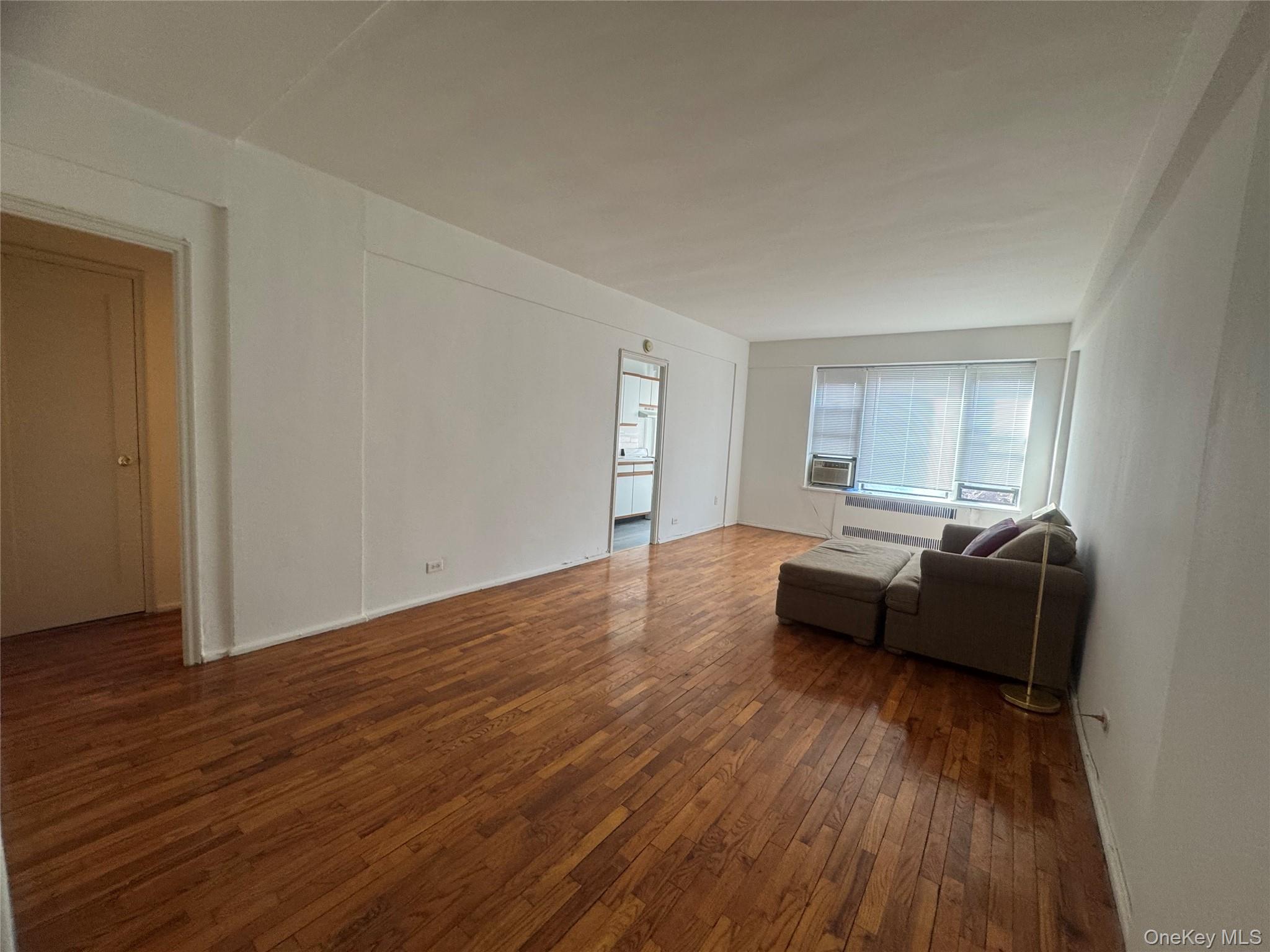 99-21 67th Road, Unit 7K Queens, NY 11375 - Photo 6 of 10 a living room with furniture and a wooden floor