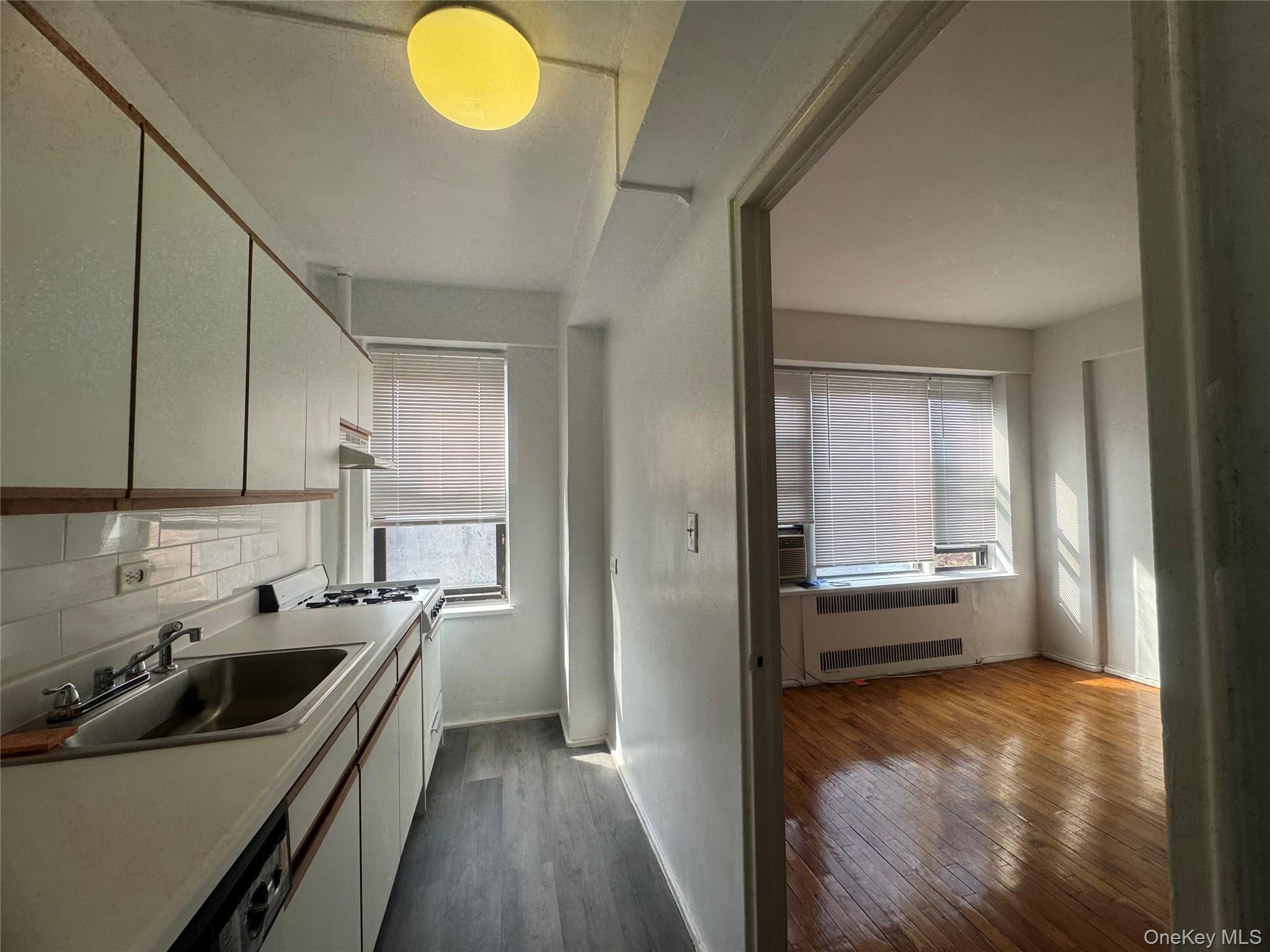 99-21 67th Road, Unit 7K Queens, NY 11375 - Photo 7 of 10 a kitchen that has a sink and a stove in it