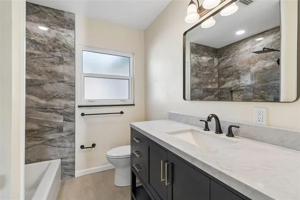 a bathroom with a sink a toilet and mirror
