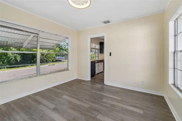 a view of empty room with wooden floor and fan