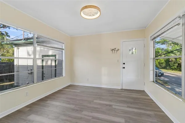 a view of empty room with wooden floor and fan