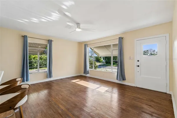 a view of a big room with wooden floor and windows