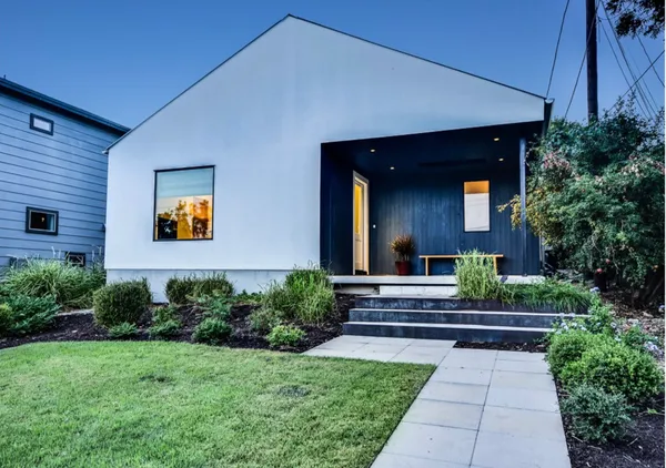 a view of a house with brick walls and a yard