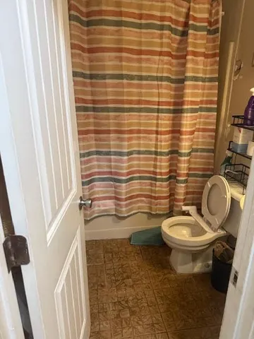 a bathroom with a granite countertop toilet and a sink