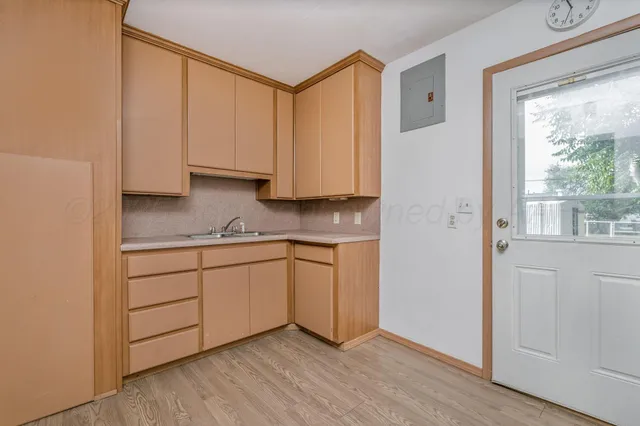 a room with granite countertop cabinets and wooden floor