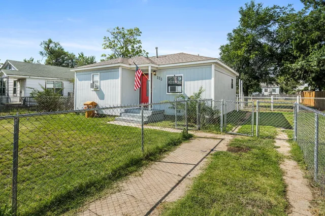 a view of a house with backyard and sitting area