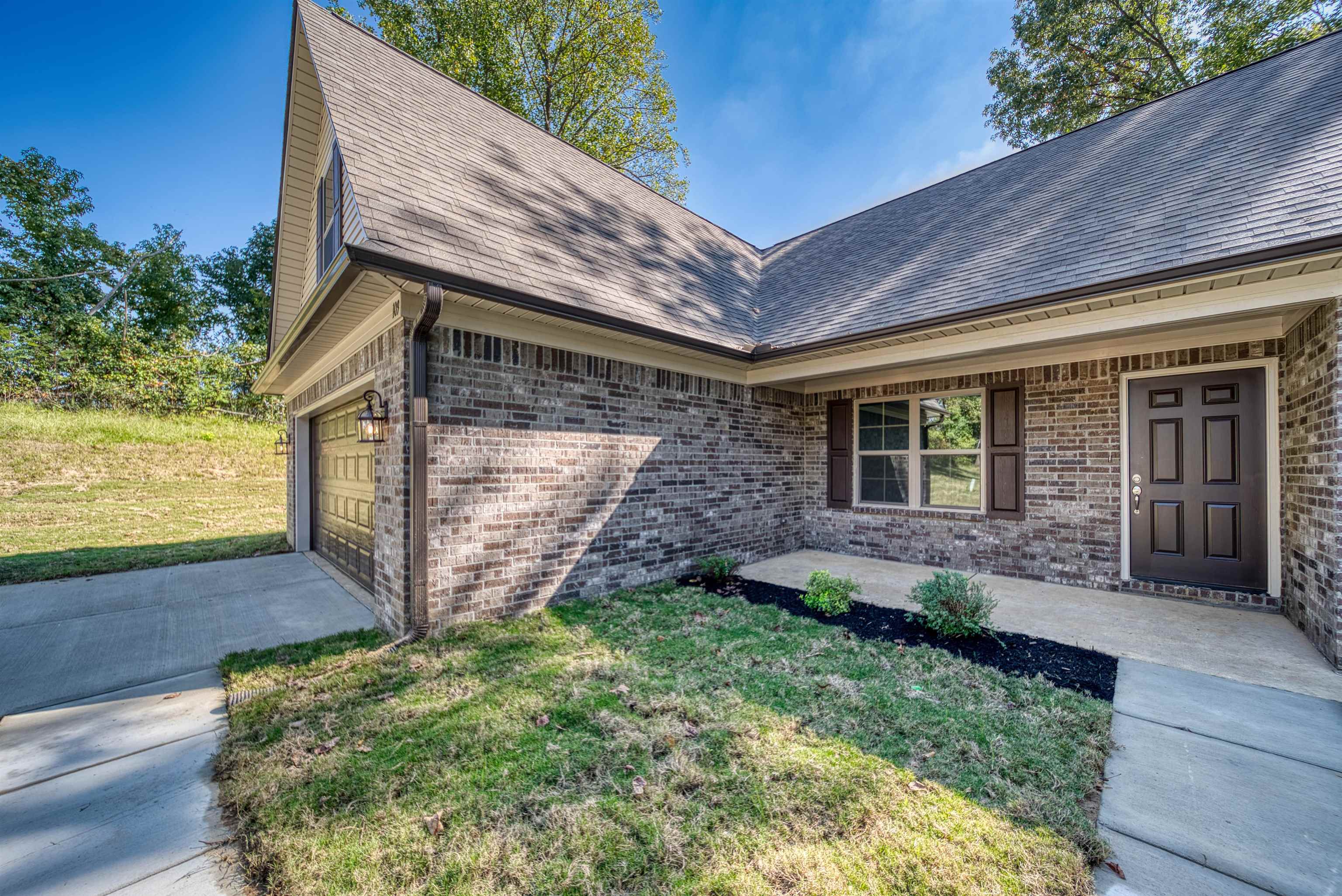 109 Walnut Ridge Ripley, TN 38063 - Photo 34 of 39 Entrance to property featuring a shingled roof, brick siding, a yard, and an attached garage