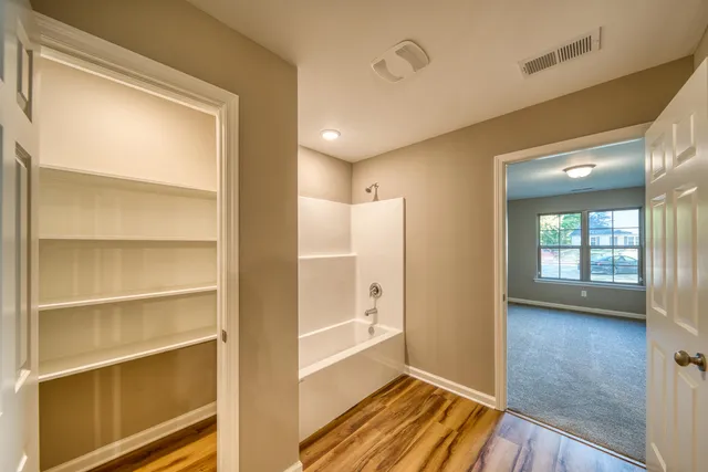 a view of a room with wooden floor and windows
