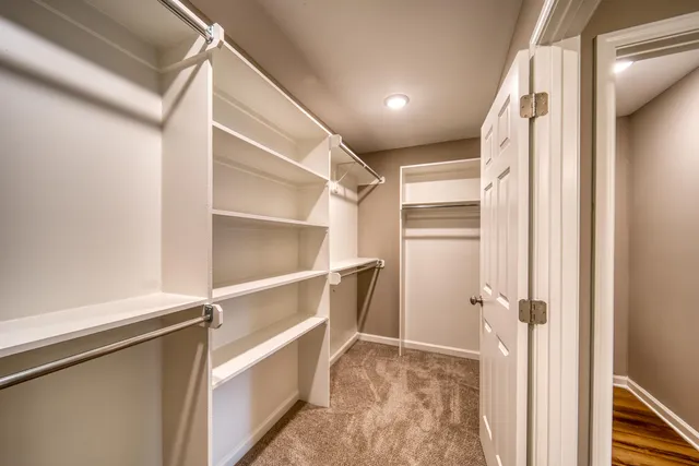 a view of walk in closet with empty racks