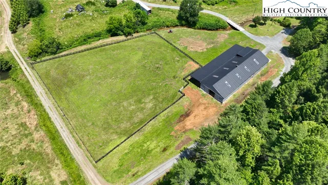 an aerial view of a residential houses with outdoor space and swimming pool
