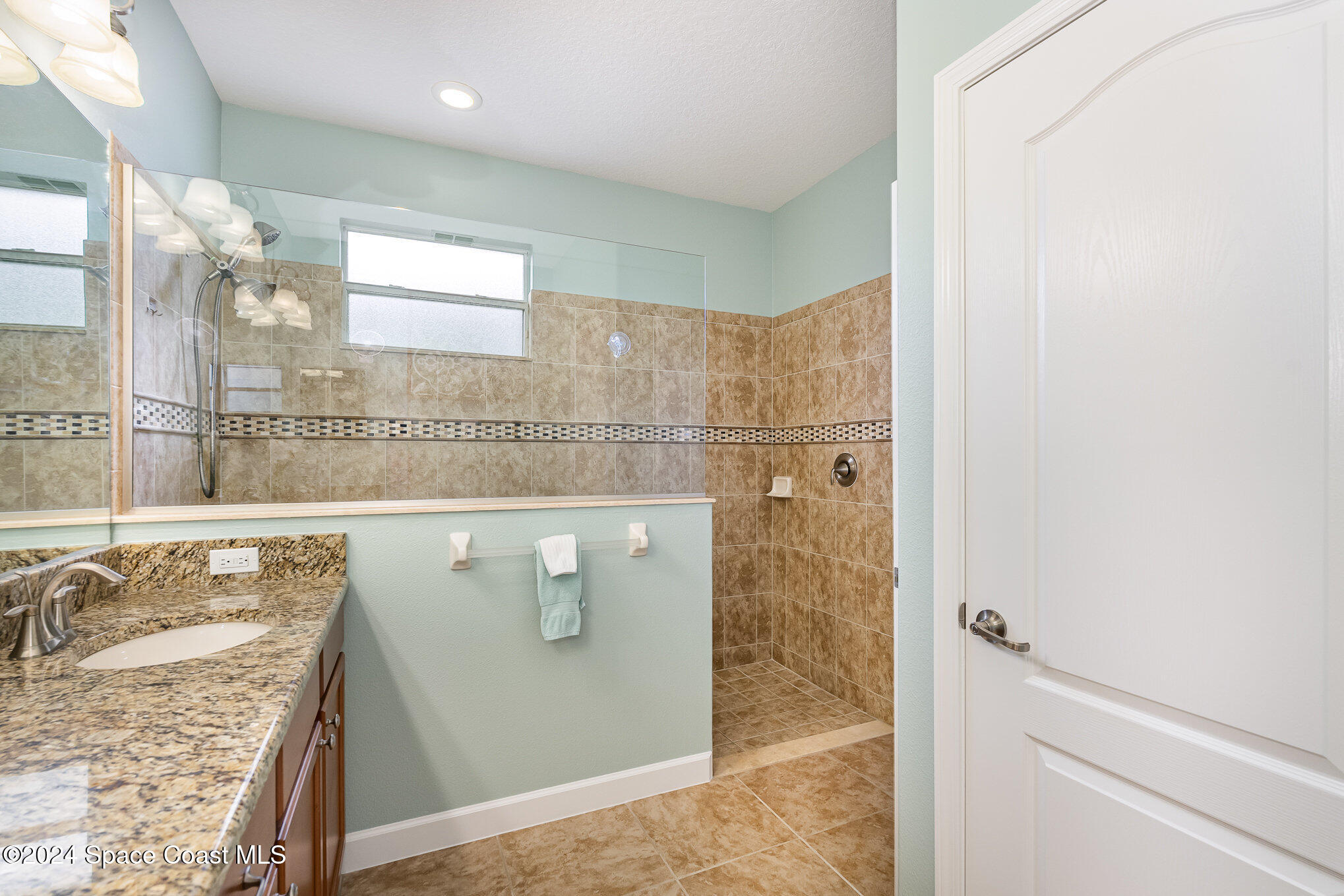 3354 Sansome Circle Melbourne, FL 32940 - Photo 19 of 81 a bathroom with a granite countertop sink a mirror and shower