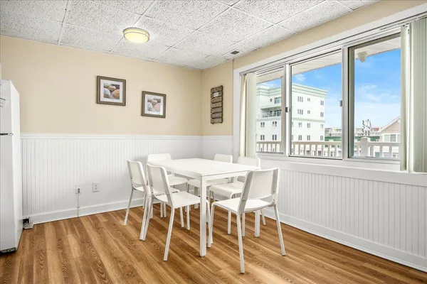 a living room with stainless steel appliances furniture and a kitchen view