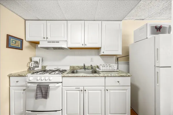 a kitchen with stainless steel appliances granite countertop a sink and a stove