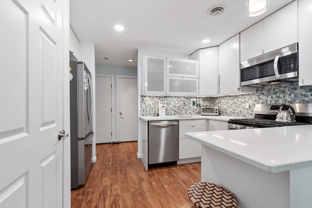 1 Concord Greene, Unit 7 Concord, MA 01742 - Photo 17 of 31 a kitchen with a sink stainless steel appliances and white cabinets