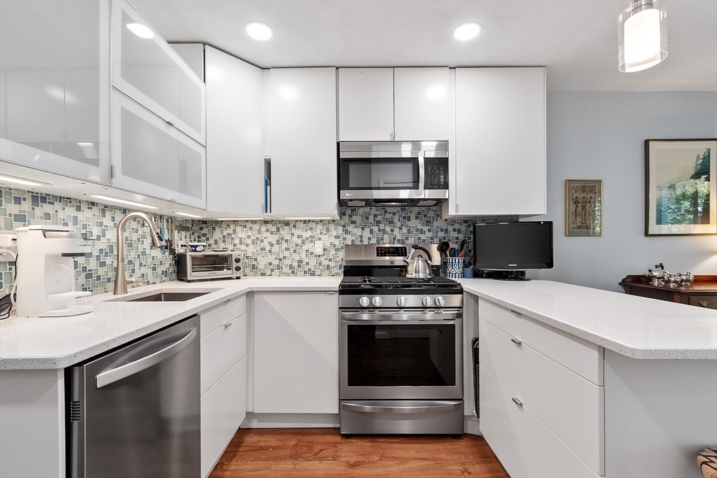 1 Concord Greene, Unit 7 Concord, MA 01742 - Photo 18 of 31 a kitchen with stainless steel appliances a stove sink microwave and cabinets