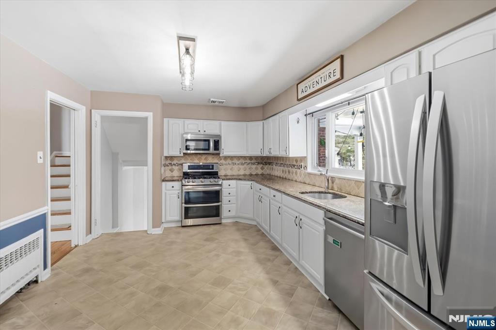 922 Wildwood Road Oradell, NJ 07649 - Photo 15 of 42 a kitchen with granite countertop a refrigerator oven a sink and dishwasher