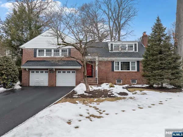 a front view of a house with a yard covered in snow