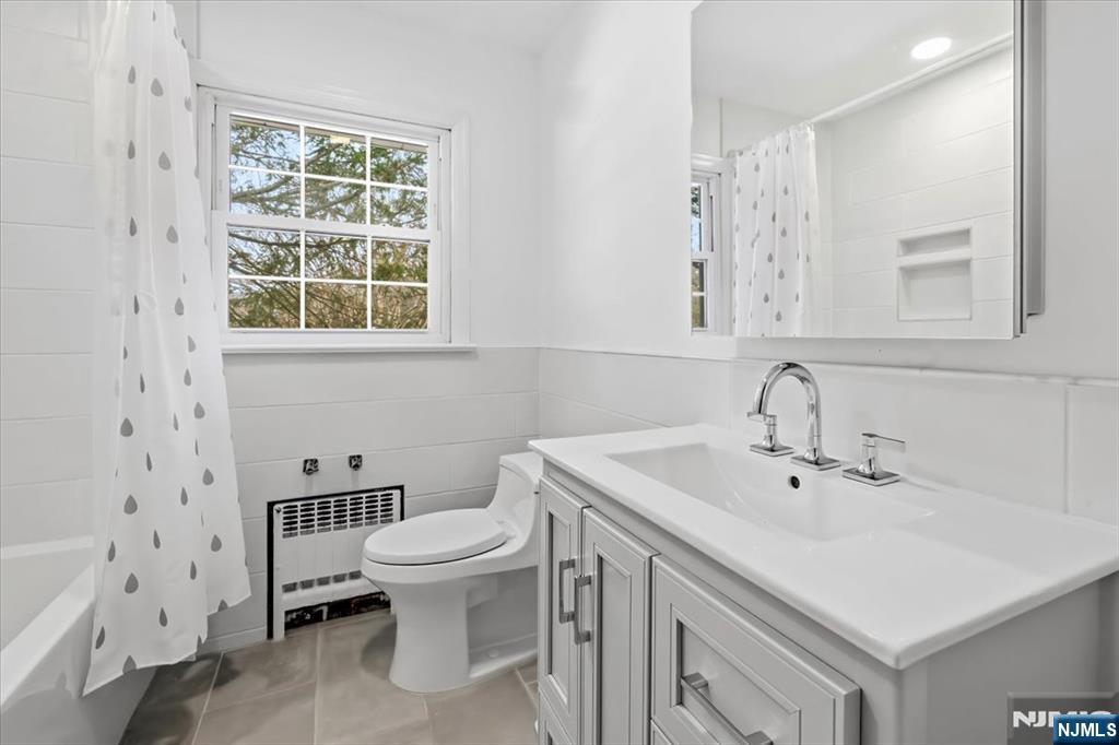 922 Wildwood Road Oradell, NJ 07649 - Photo 27 of 42 a bathroom with a sink a toilet and a large mirror