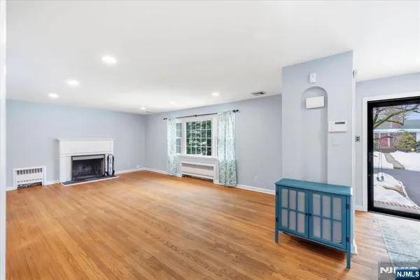 a view of empty room with wooden floor and fireplace