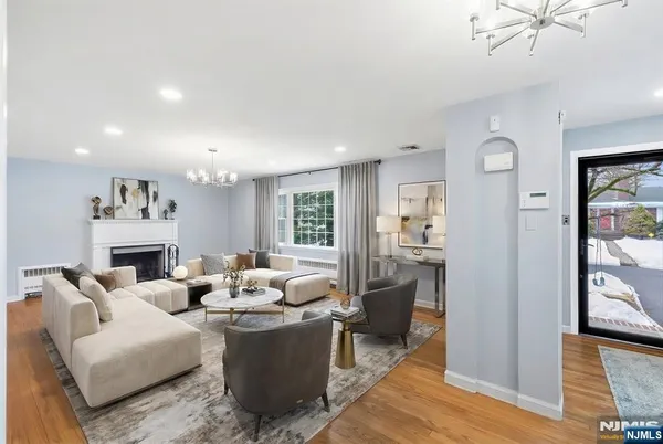 an empty room with wooden floor fireplace and windows