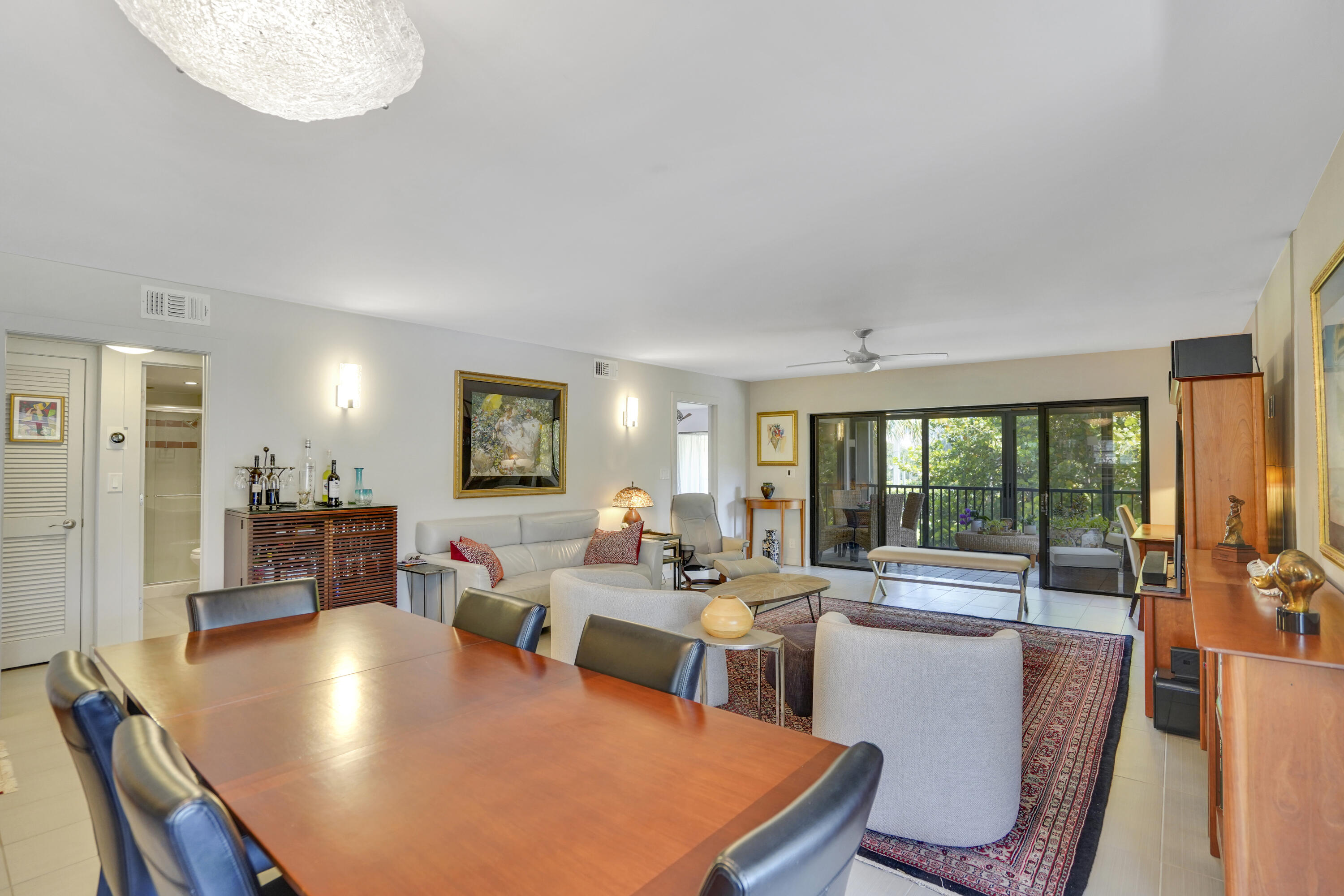 102 Clubhouse Circle Jupiter, FL 33477 - Photo 16 of 35 a living room with furniture a large window and a dining table