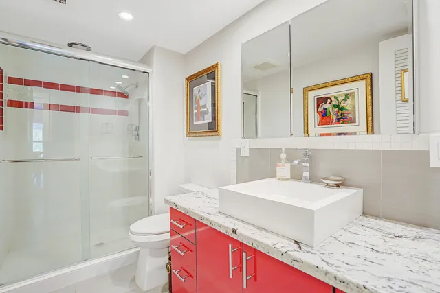 a bathroom with a sink a toilet and shower