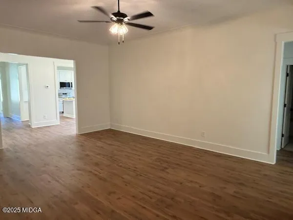 a view of empty room with wooden floor