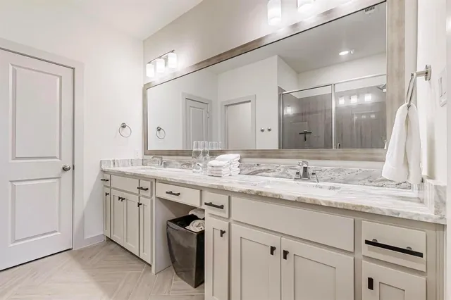 a en suite bathroom with a shower sink and mirror