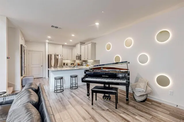 a living room with kitchen appliances furniture and a large window