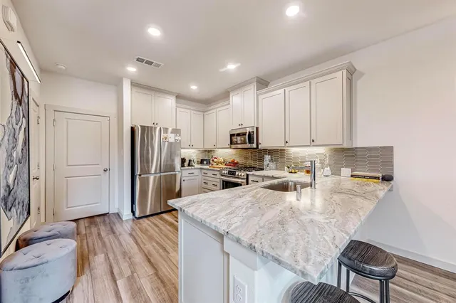 a kitchen with refrigerator cabinets and wooden floor
