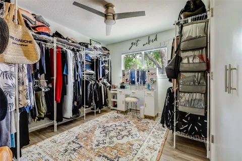 a view of walk in closet with clothes and shoes