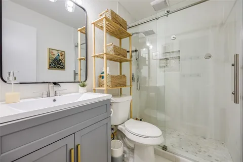 a bathroom with a sink toilet a mirror and shower