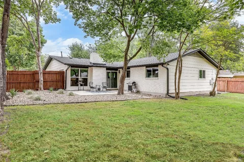 a view of a house with backyard and sitting area