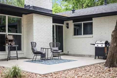 a view of a patio with a table and chairs