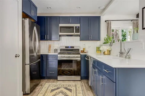 a kitchen with stainless steel appliances granite countertop a refrigerator stove and sink
