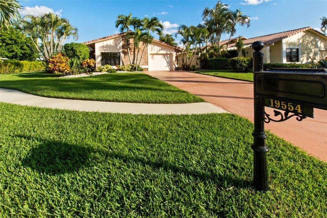 19554 Sea Pines Way Boca Raton, FL 33498 - Photo 2 of 26 a front view of a house with a yard