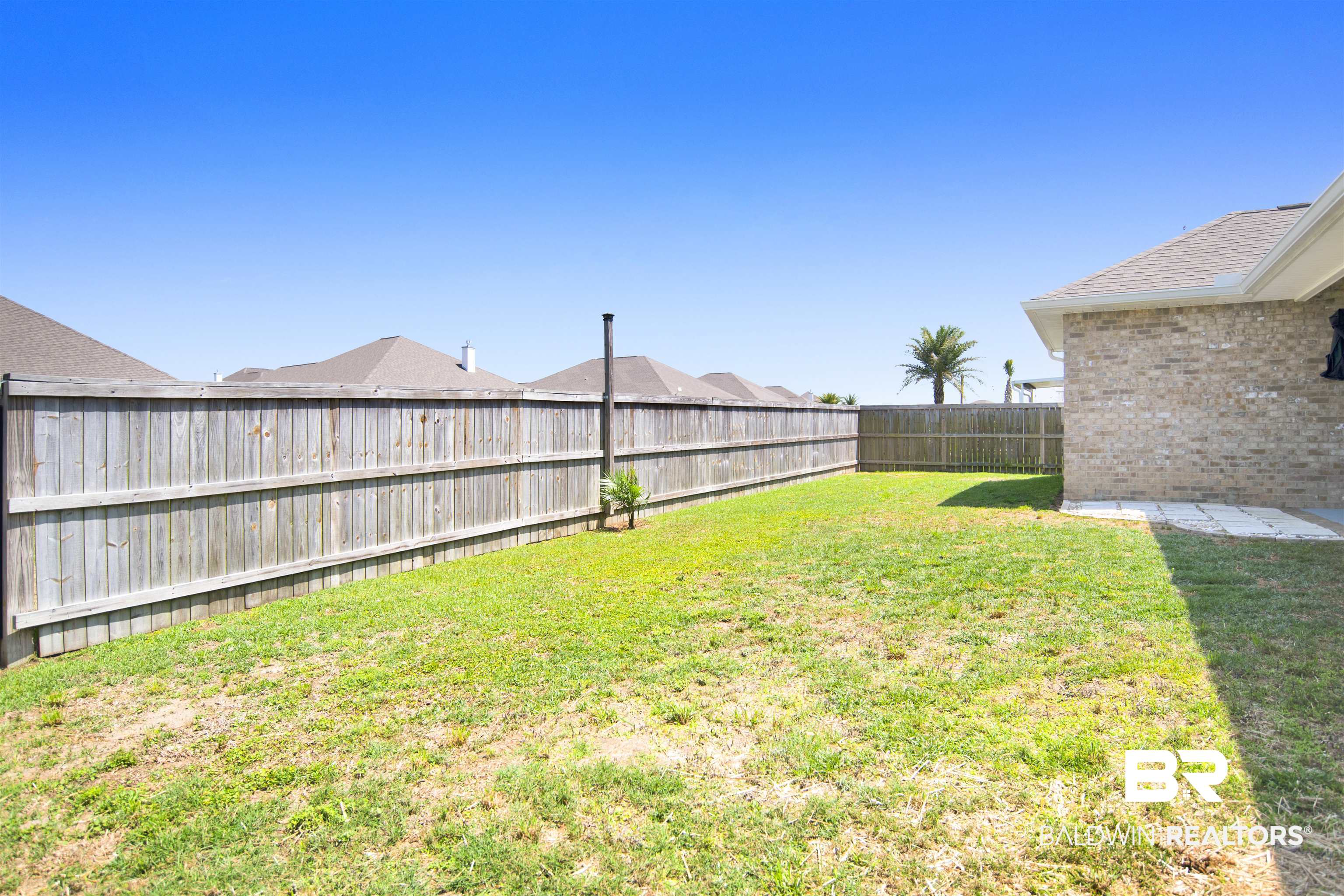 8493 Bronze Lane Foley, AL 36535 - Photo 33 of 38 Expansive backyard featuring a lush lawn, privacy fencing, and a brick exterior